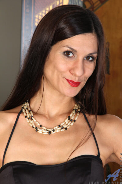 Sexy mature Leah Harris sheds her black dress to finger fuck her hot beaver Image #1