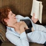 Short-haired ginger Gigi strips and masturbates while reading a book