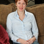 Short-haired ginger Gigi strips and masturbates while reading a book