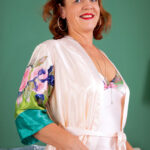 Playful mature woman Iris smooths lotion onto her legs & spreads her pussy